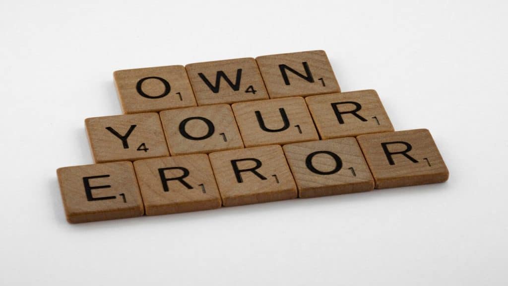 Wooden blocks spelling out “own your error”