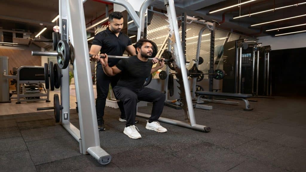 A man doing squats at the gym