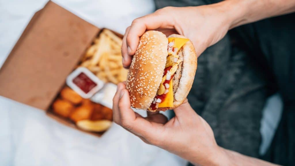 A man eating cheeseburger and fries