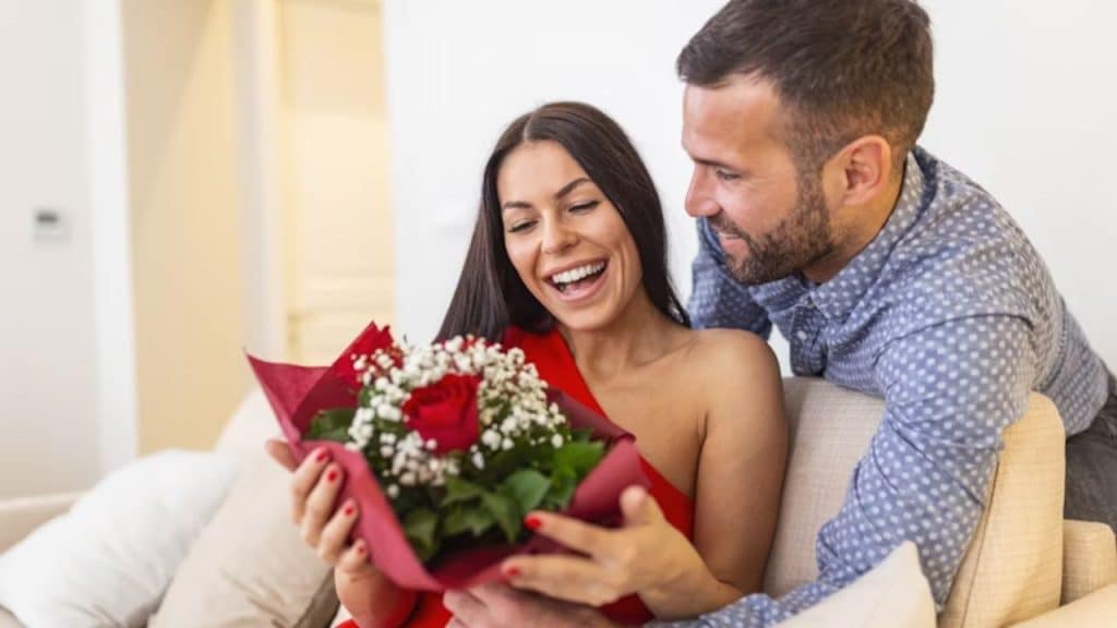Man expressing appreciation with a warm smile and flowers