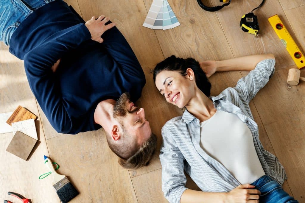 A man and woman laying at the floor 