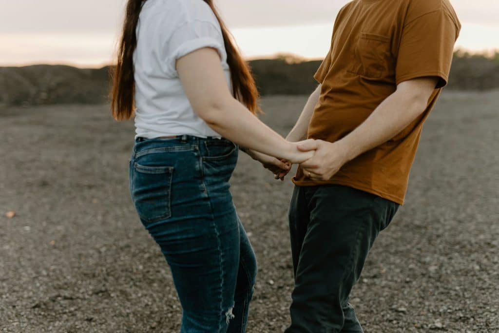 A man and woman holding each other hands