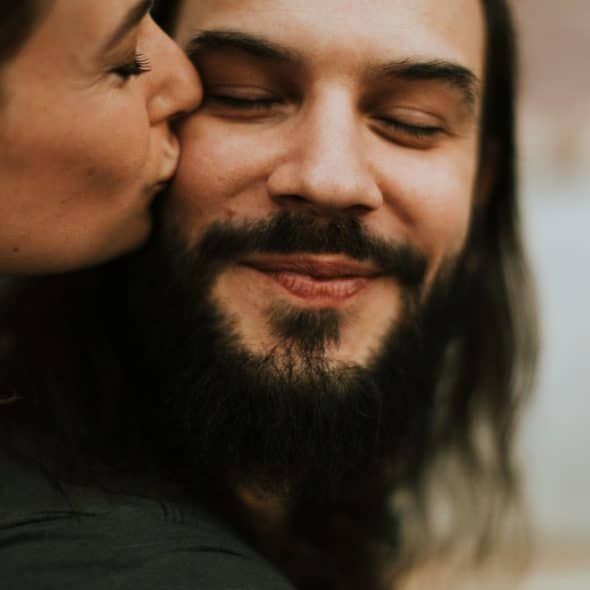 A woman kissing a man’s face