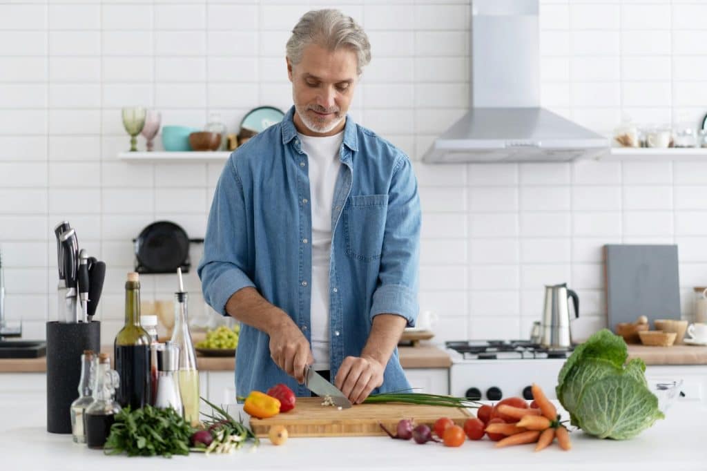 A man cutting a spring onion