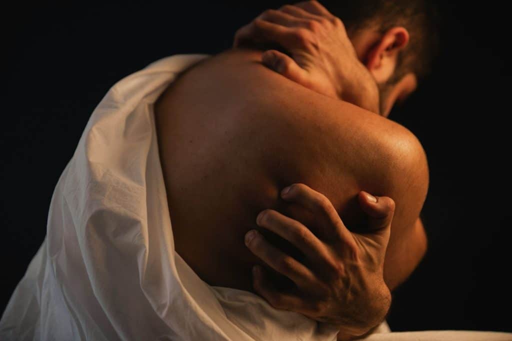 A man that looks scratching his back