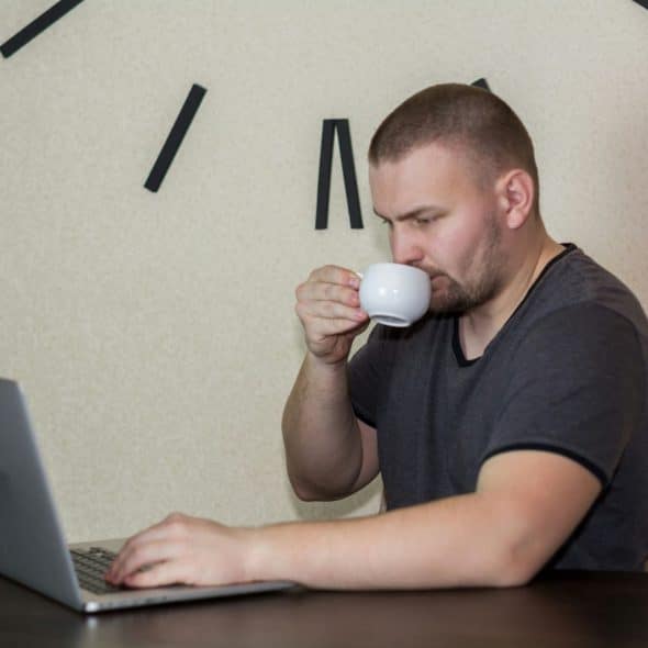 A man drinking coffee while working