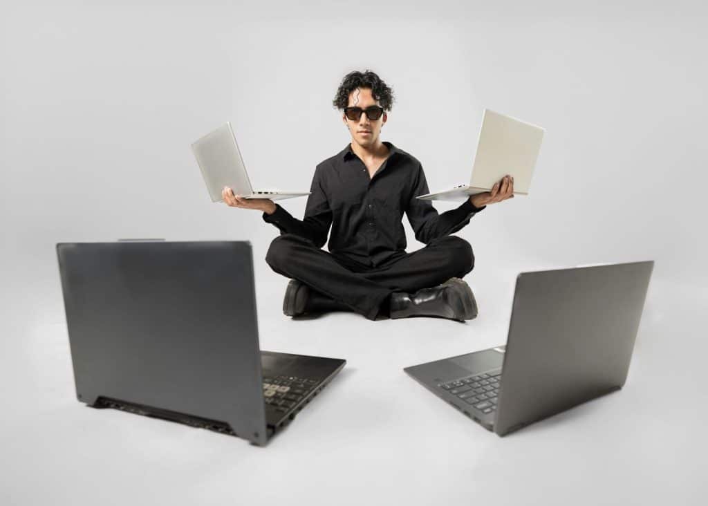 A man with multiple laptops