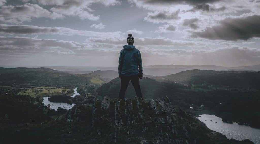 A man standing at the top of the mountain