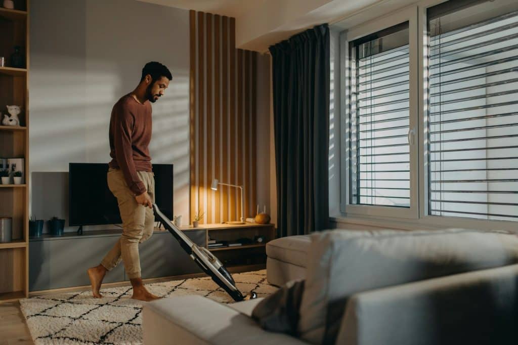 A man using a vacuum cleaner for cleaning