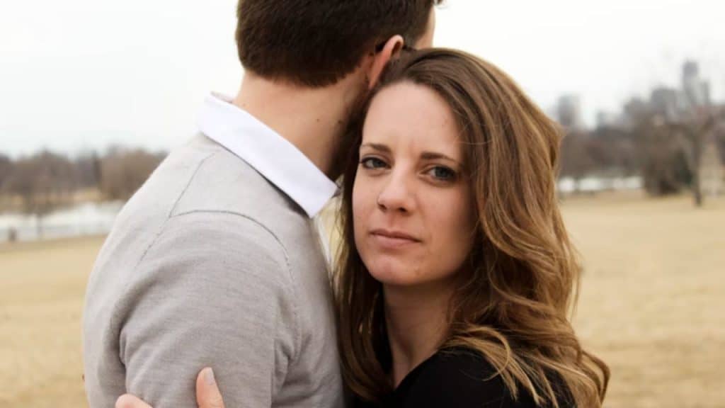 Woman looking concerned while man avoids eye contact