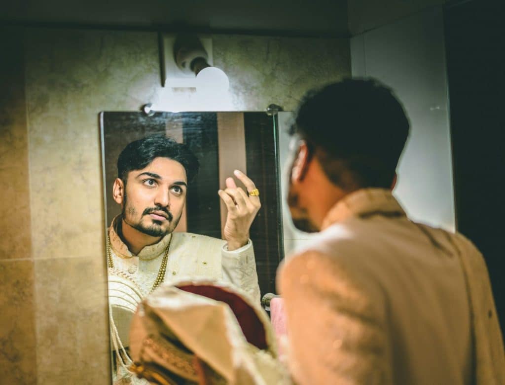 A man looking at himself at the mirror