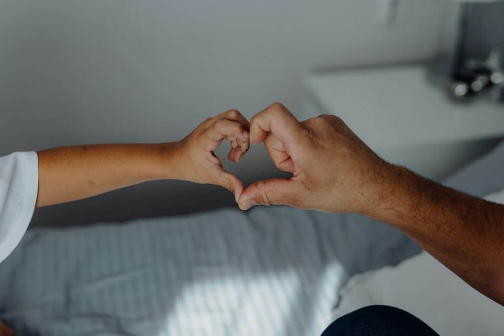 Two person with their hand forming a heart shape