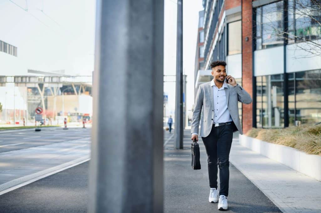 A happy man walking on the sidewalk alone