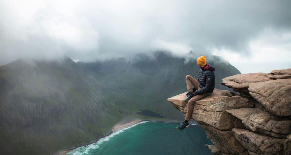 A man sitting at the edge of rock