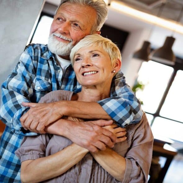 An elderly couple looking happy.