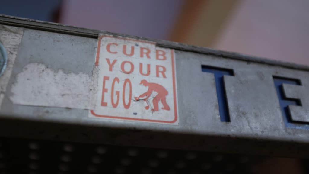 A sign saying “curb your ego”.