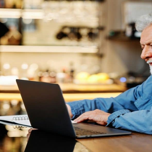 An older man studying at a cafe.