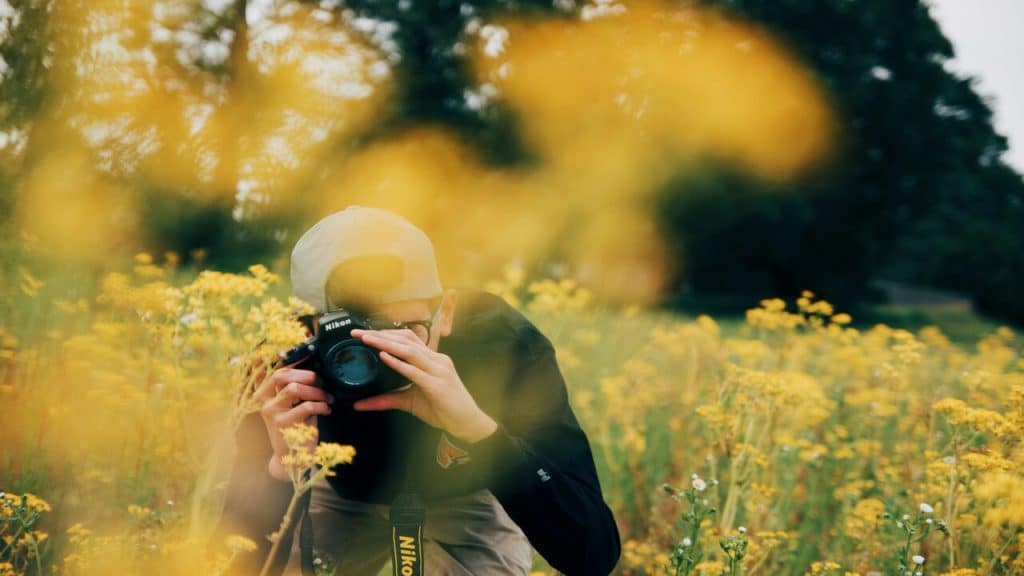 A man taking photos of flowers.