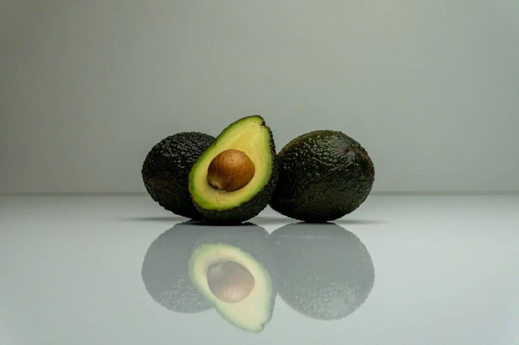 A half avocado and a whole avocado.