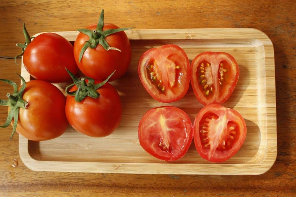 A whole tomatoes and half tomatoes.