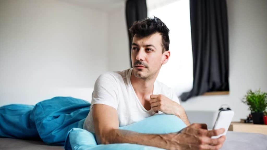 Man taking a mindful break from online dating by turning off notifications.