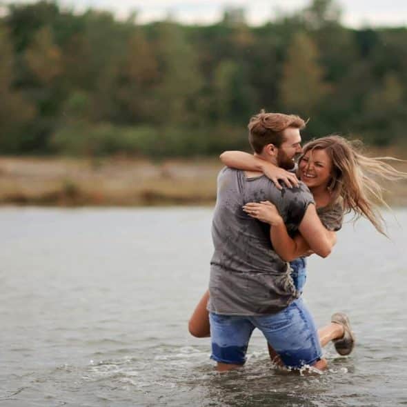 A couple hugging and laughing in the lake