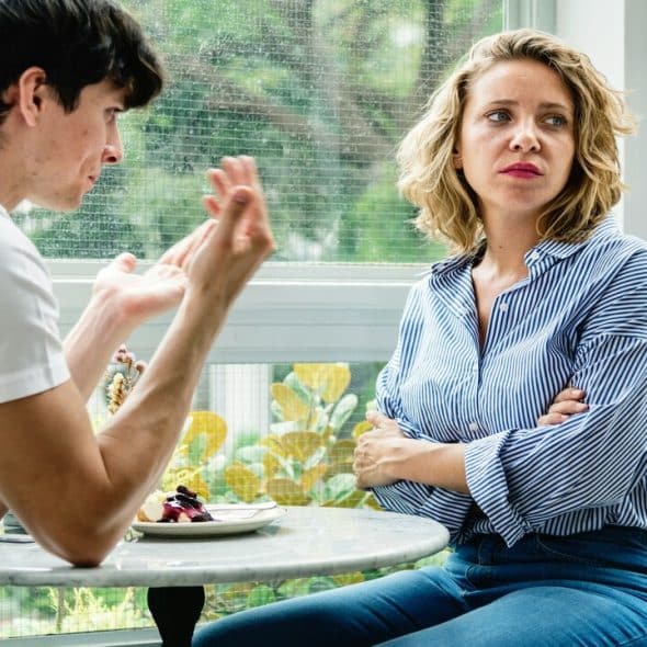 A couple looking sad at a cafe.