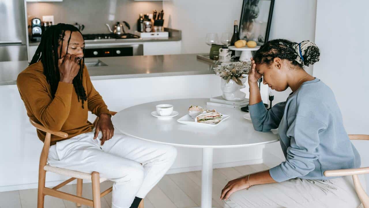 A sad couple in the kitchen.