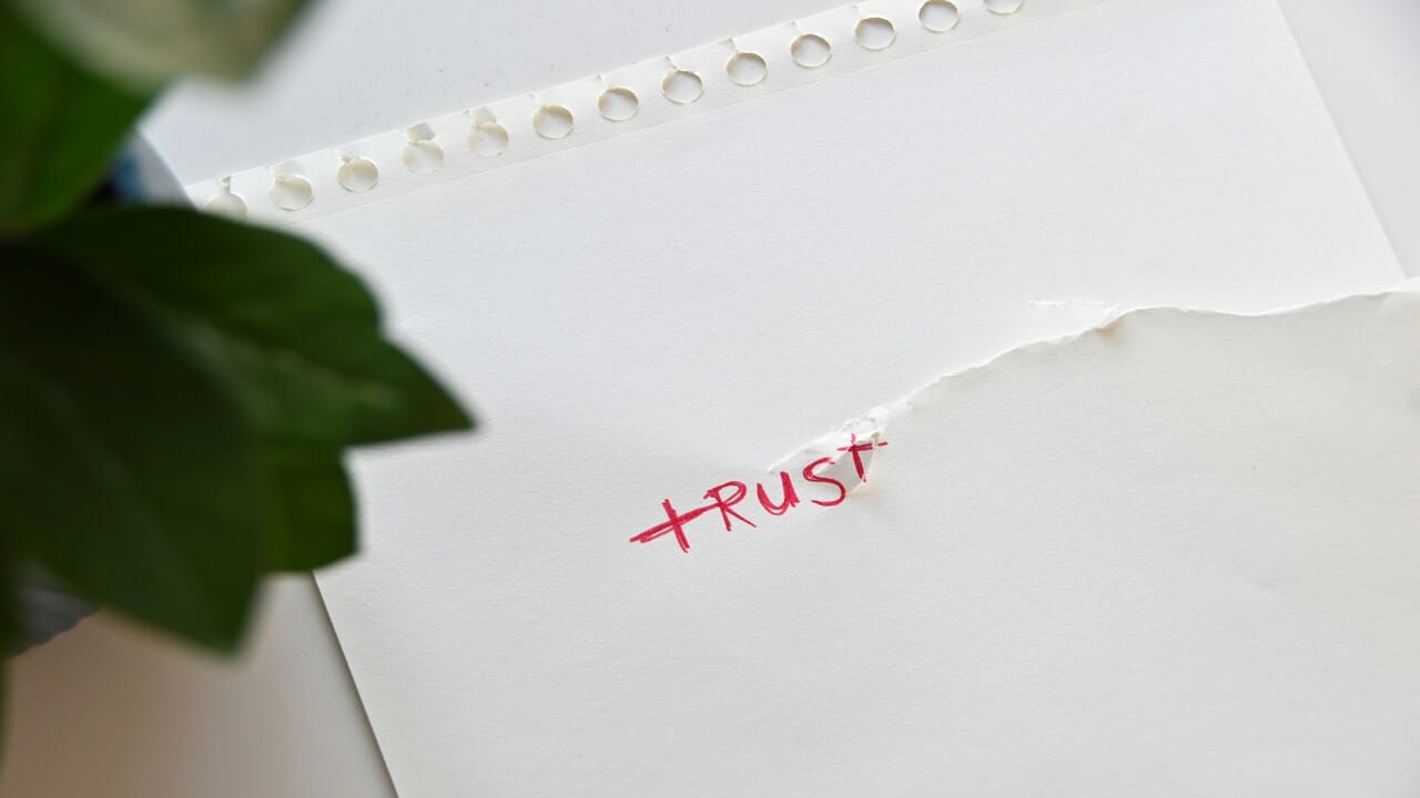 A torn paper with the word “trust” written on it.