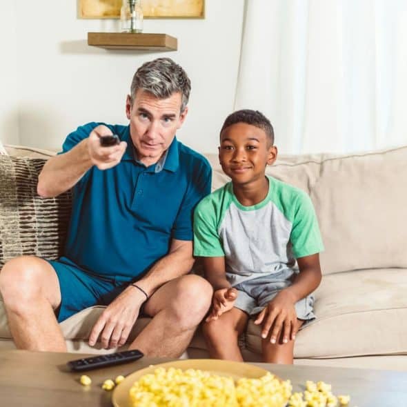 A picture of a man watching with a kid