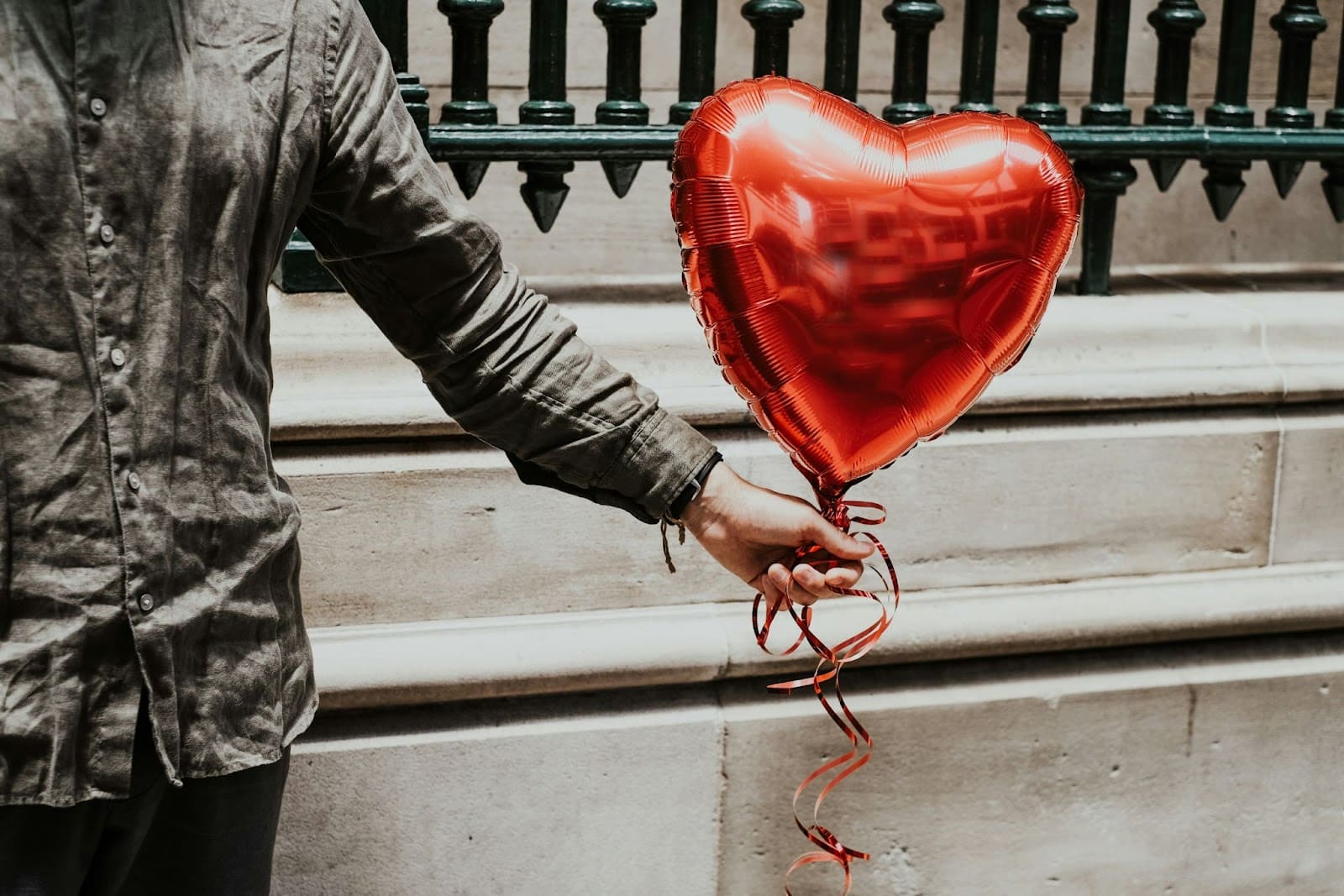 A person holding a heart balloon.