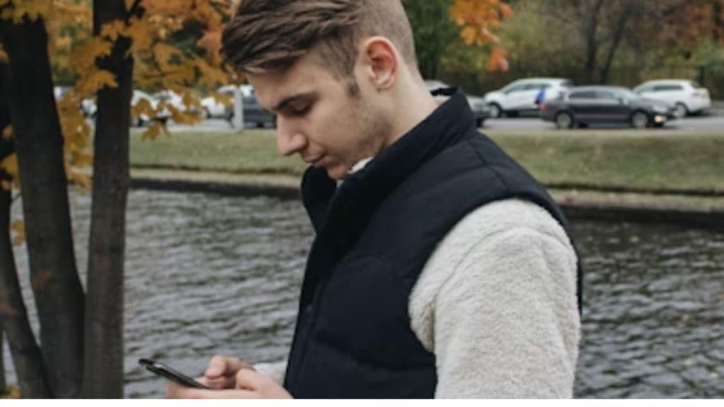 Man refreshing his dating profile on his phone.