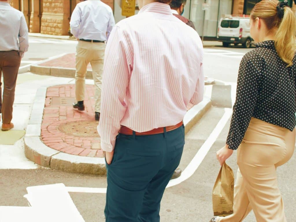 A man walking on the sidewalk with a woman.