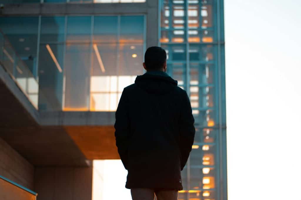 A man standing in front of a tall building.