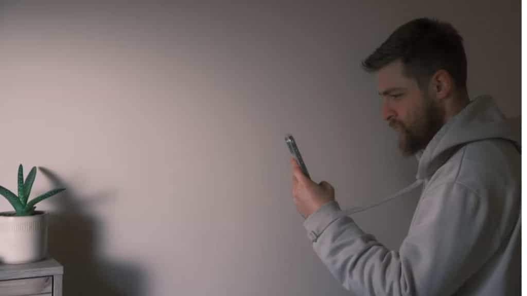 Man evaluating a suspicious dating profile on his phone.