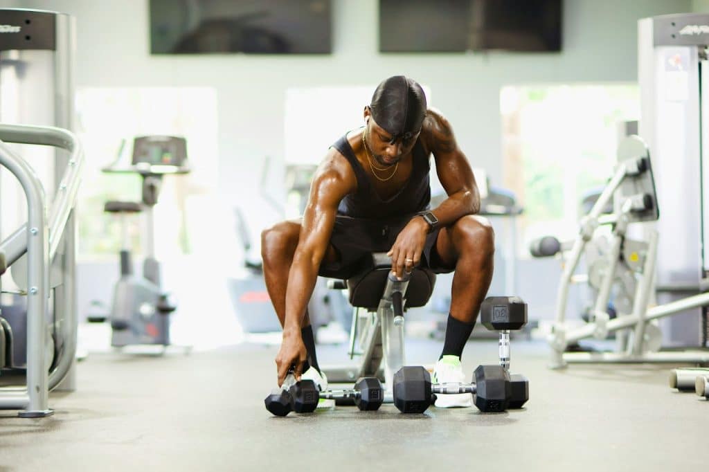 A man reaching a dumbbell.