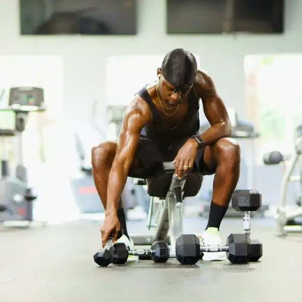 A man reaching a dumbbell.