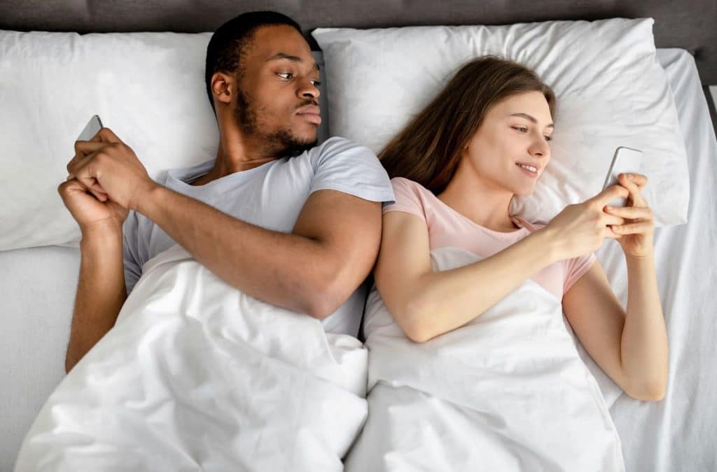 A man secretly  looking at girlfriend’s phone.
