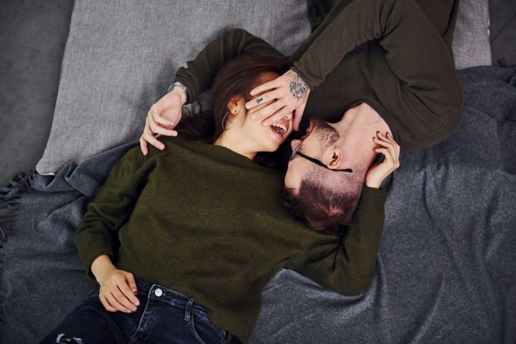 A couple lying at the bed.