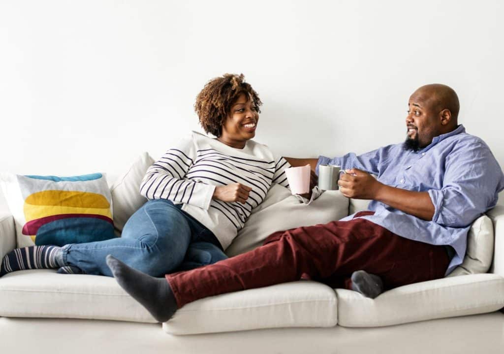 A couple sitting at the sofa and talking