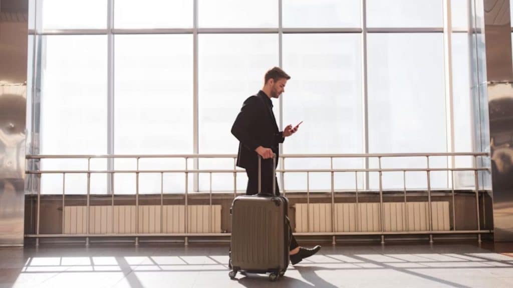 A man writing a supportive message to his partner while traveling