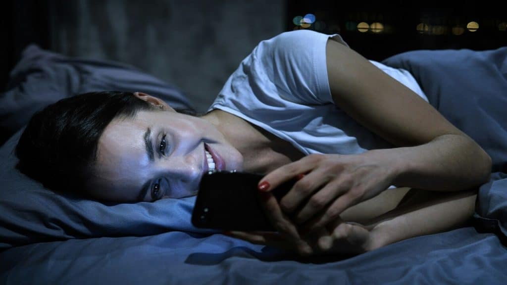 A woman using her phone in bed