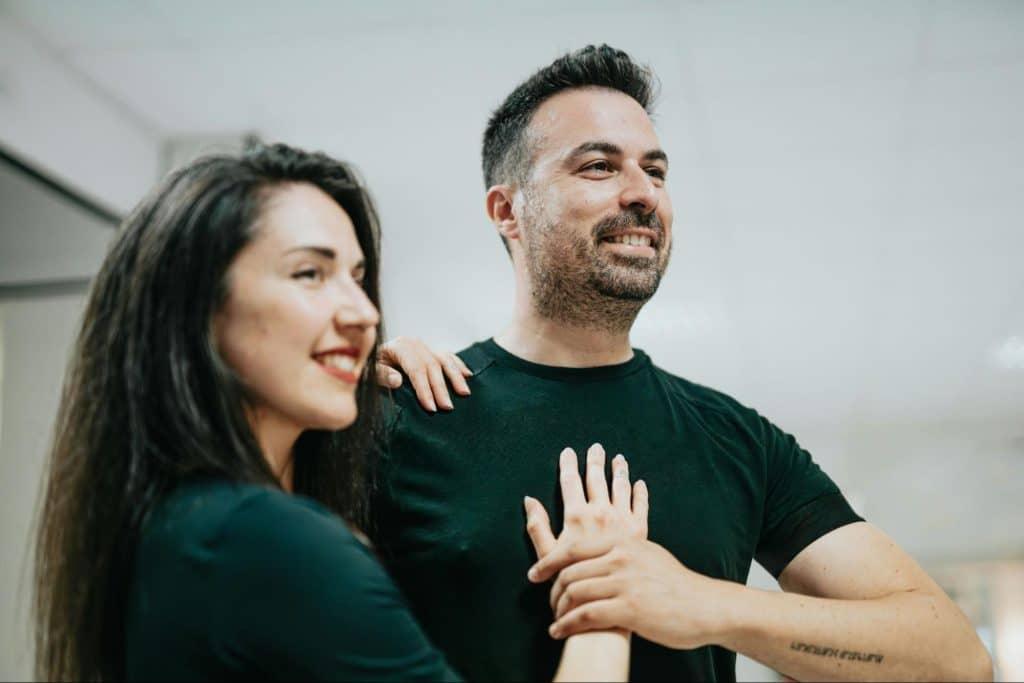 A woman holding a man’s chest