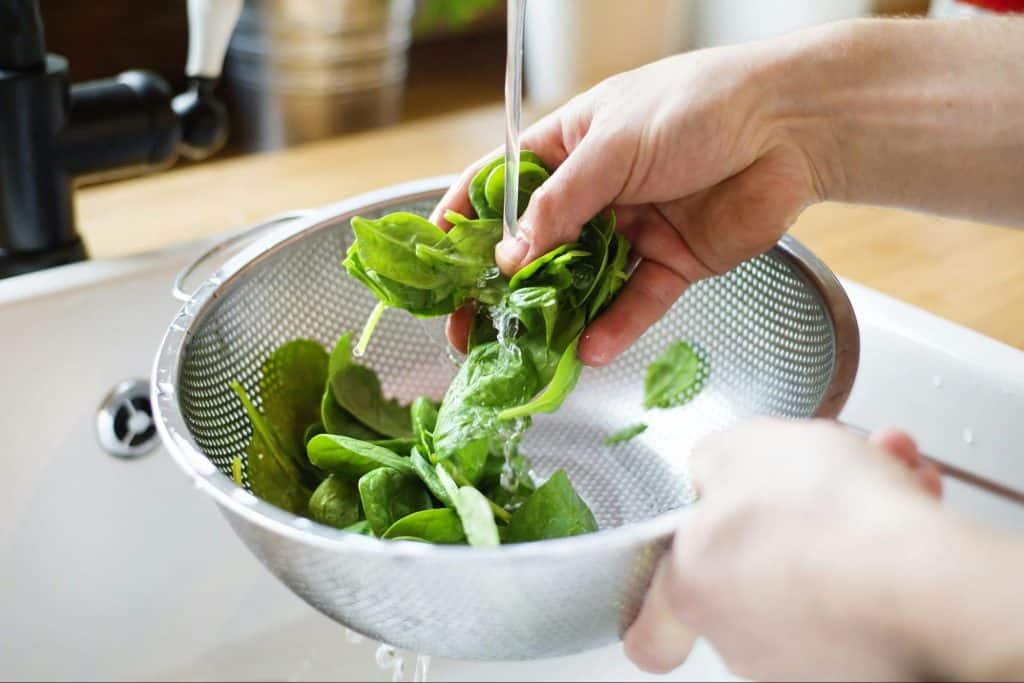 A picture of spinach being washed.