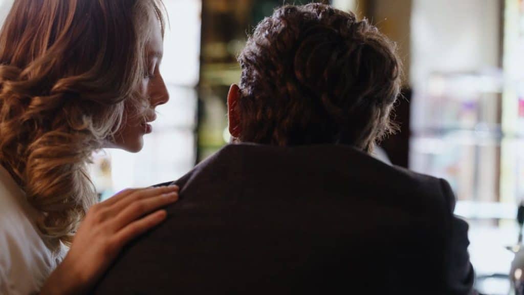 Woman playfully touching a man’s shoulder during a conversation
