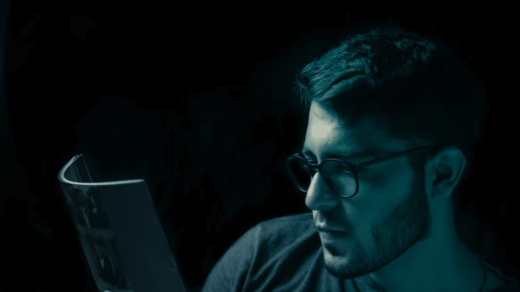A man reading in the dark.