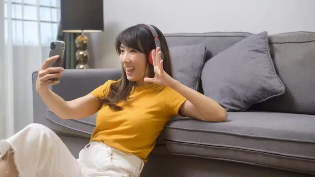 Woman smiling during a video chat, clearly emotionally engaged with partner.