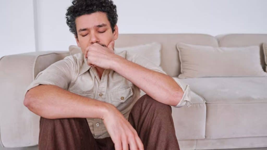 Man experiencing gas discomfort at home.