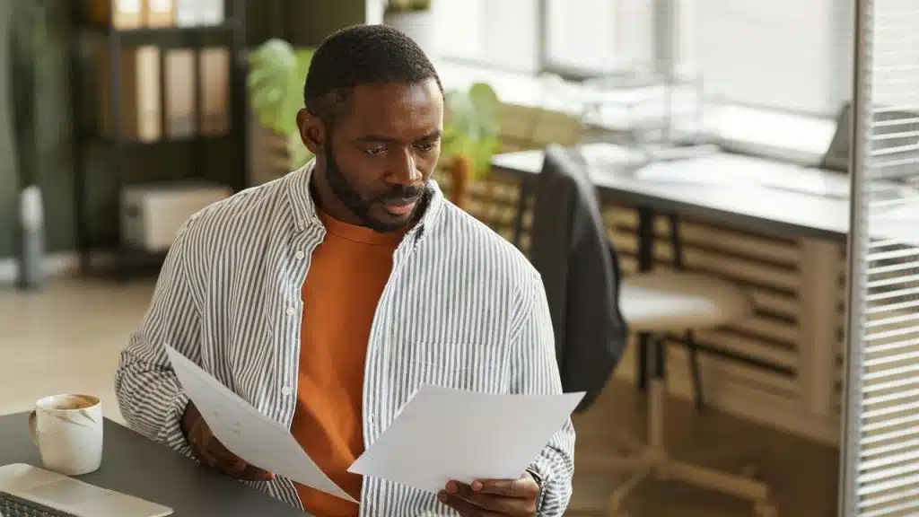 A man reviewing papers at his desk.