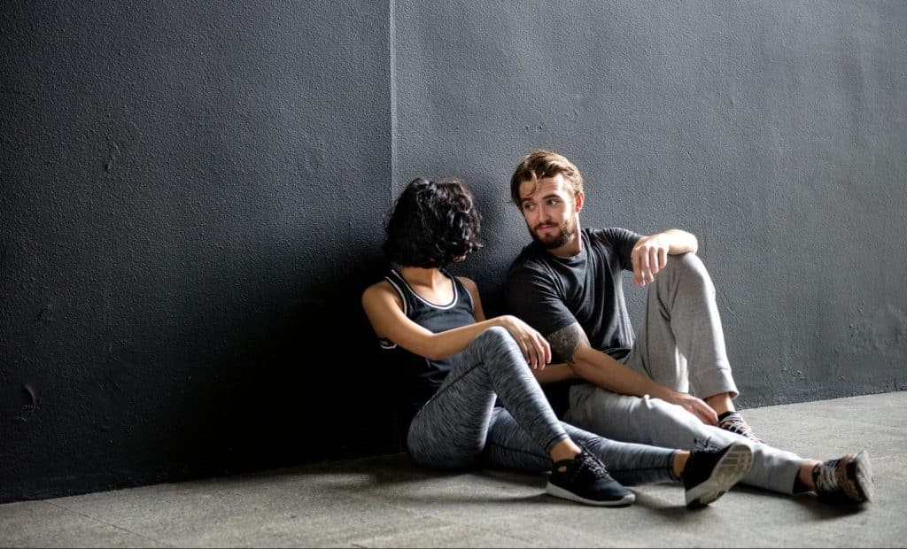 A man saying the words to a woman while sitting on the floor